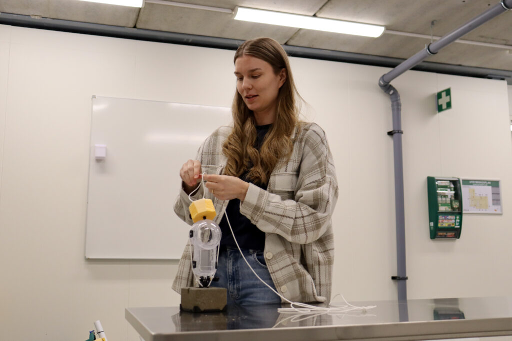 Frida Tornberg justerar en undervattenskamera inne på BalticWaters Fish Laboratory.